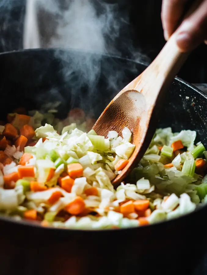 Add the diced carrots, celery, and cabbage to the pot. Stir well to combine