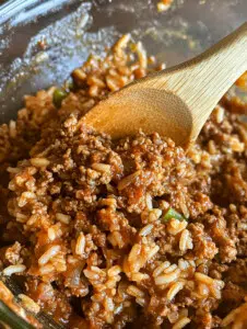 In a mixing bowl, combine ground beef, cooked rice, finely chopped onion, minced garlic, paprika, salt, black pepper, and a beaten egg. Mix thoroughly.